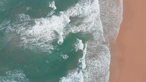 Aerial View of Sea Waves Break on Yellow Sand Beach