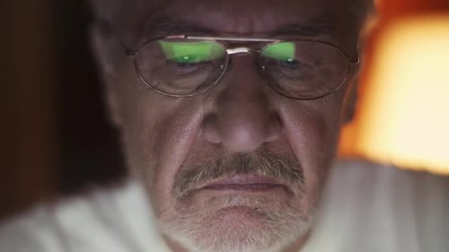 Senior Man Reads Computer Screen Close Up