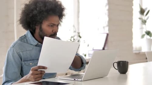 Young Adult Working at Desk With Laptop