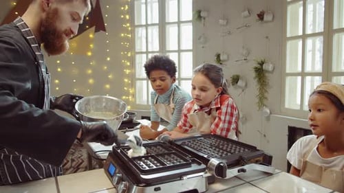 Chef Teaching Children to Make Waffles in Kitchen