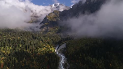 Flight Over the River and Forest in Mountain Valley Clouds in Georgia