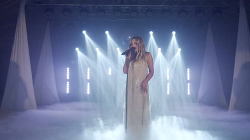 Woman Singing on Smoky Stage with Bright Lights