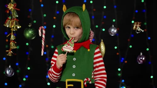 Boy Dressed as Elf Licking Christmas Lollipop