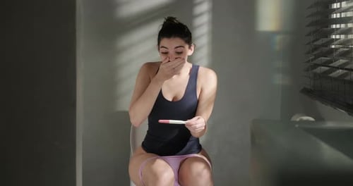 Joyful Woman Celebrates Positive Pregnancy Test at Home