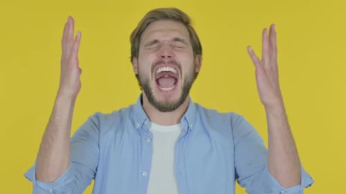 Joven gritando y gritando sobre fondo amarillo