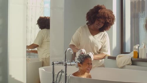 Mother Washing Daughter's Hair in Bathtub