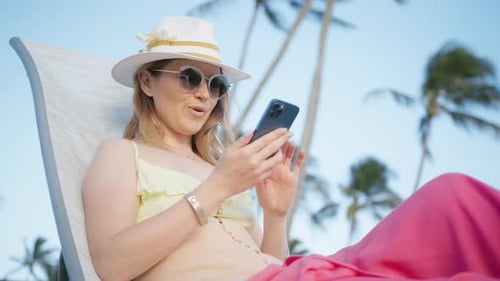 Woman Relaxing on Beach Using Phone