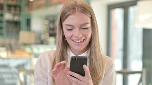 Woman Smiling While Using Cell Phone