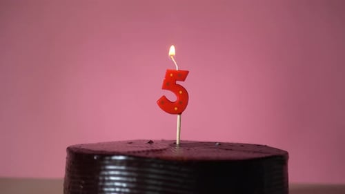 Lighting Number Five Candle on Chocolate Birthday Cake