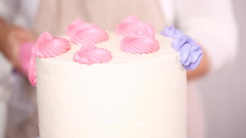 Decorating White Cake with Pastel Frosting Flowers