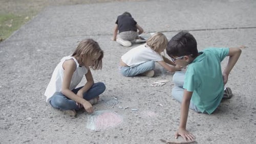 Children Drawing with Chalk Outside on Concrete