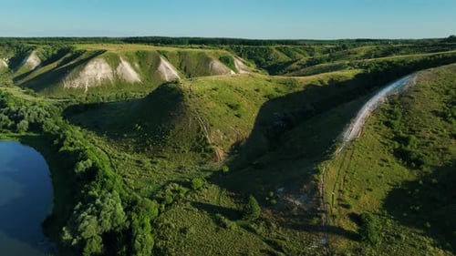 Drone View of Green Hills Rivers and Fields in Sunny Weather