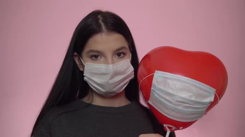 Young Adult with Mask and Heart Balloon