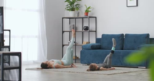 Woman and Child Exercise Together at Home