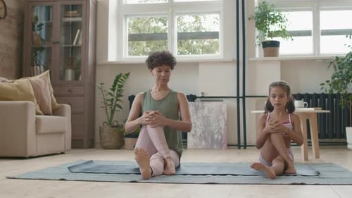 Woman and Girl Stretching on Yoga Mat Indoors