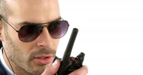 Man Speaks Into Walkie Talkie Wearing Sunglasses
