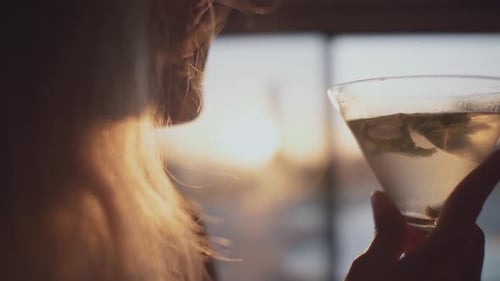 Woman Drinking Cocktail at Sunset Close Up