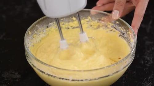 Schlage den Teig mit einem Mixer, Nahaufnahme.