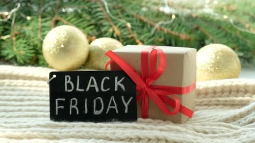 Gift Box and Promotional Sign of Black Friday on the Christmas Background