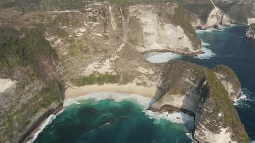 Aerial view of a tropical beach and towering cliffs