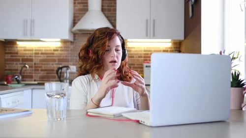 Woman Using Laptop for Video Call in Kitchen