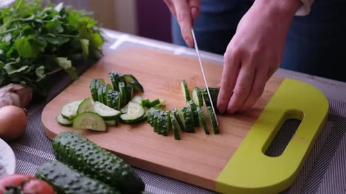Close Up of Slicing Cucumber on Cutting Board