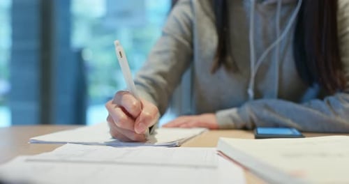 Woman study the note on paper at library