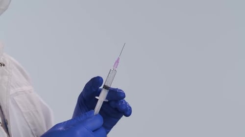 Medical Professional Prepares Syringe with Blue Gloves