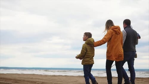 Family Walking Along the Beach Flying a Kite