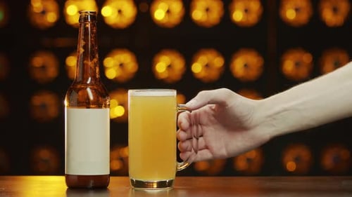 Beer Bottle and Mug in Bar with Golden Lights