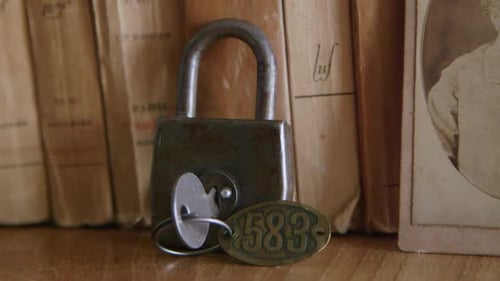 Vintage Padlock and Key with Aged Books