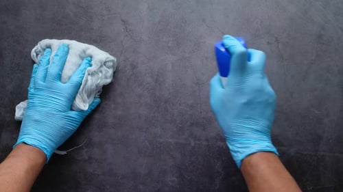 Cleaning Dark Gray Surface With Gloves And Spray