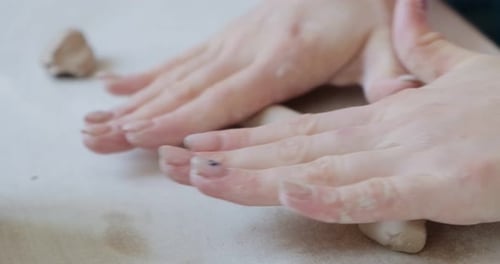 Hands Shaping Clay into a Cylinder