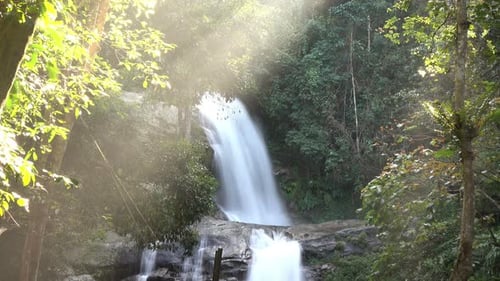 Wasserfall im Wald mit Sonnenlicht