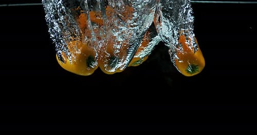 Yellow Peppers Dropping into Water in Slow Motion