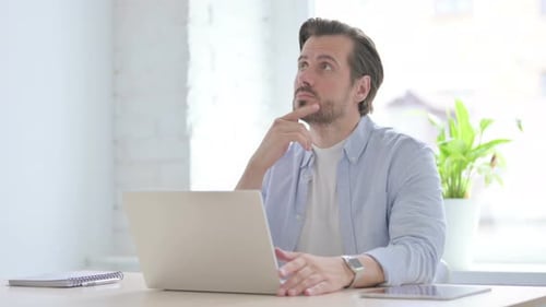 Man Typing on Laptop in Bright Office