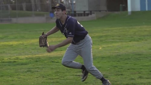 A young man playing catch with a baseball.