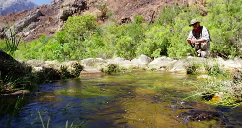 Fisherman fly fishing in river