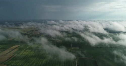 Green Fields Of Aerial View Can Be Seen Through The Clouds.