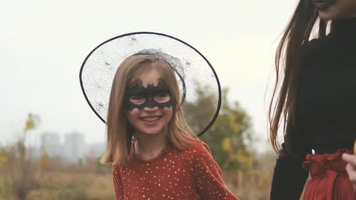 Girl and Adult in Halloween Costumes in Rural Setting