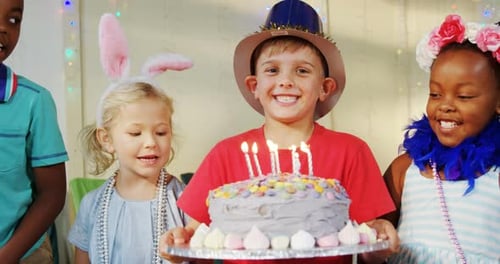 Kids Celebrating a Birthday Party with Cake and Candles