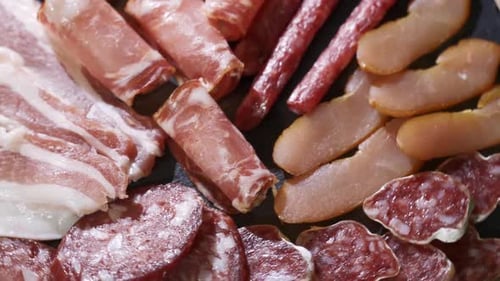 Assorted Deli Meats, Ham, Salami, Bacon and Tomatoes on the Black Stone Tray