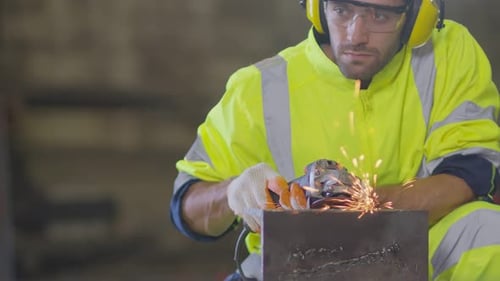 Man Grinding Metal with Sparks in a Workshop