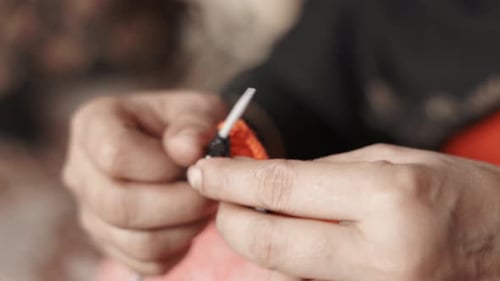 Woman's hands knitting with black and red wool and needle crafts. Close up of knit work tie-up hand
