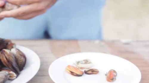 Man Preparing Fresh Mussels on a Table