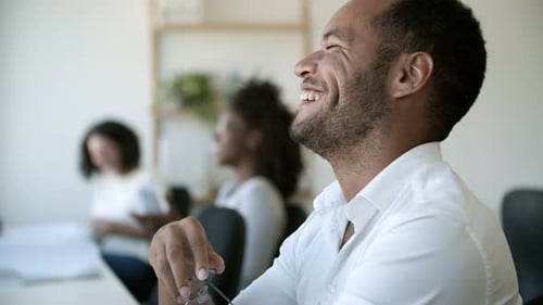 Side View of Laughing African American Man at Office.