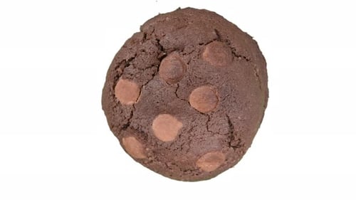 Brown peanut butter chocolate cookie spinning on white background