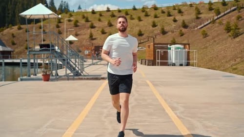 Young man running fast and intense in forest