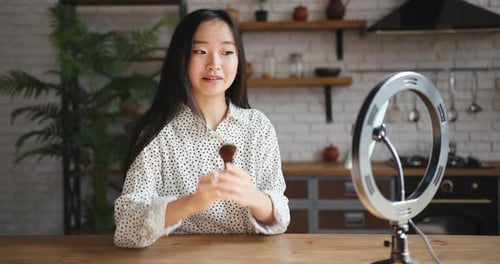 Mujer bloguera de belleza asiática coreana filmando un tutorial diario de rutina de maquillaje