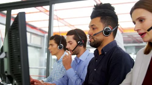 Business executives with headsets using computer